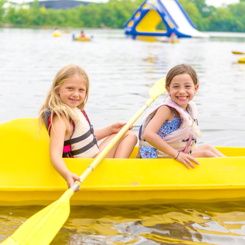Two girl campers paddling in a kayak