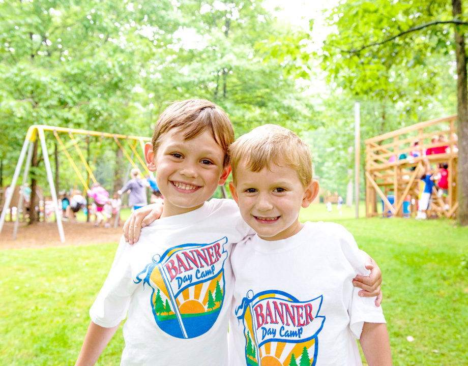 Two boy campers smiling together in Banner Day Camp shirts